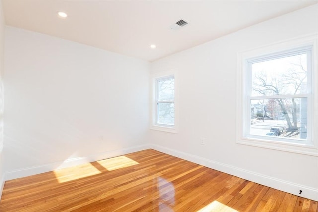 spare room featuring recessed lighting, visible vents, light wood-style flooring, and baseboards