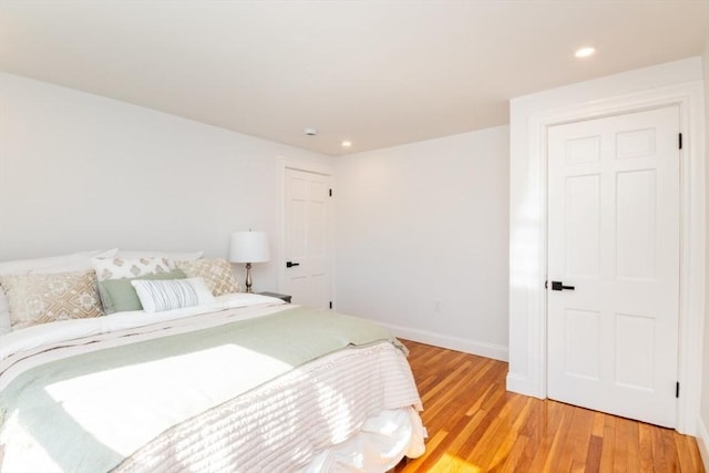 bedroom with light wood finished floors, baseboards, and recessed lighting