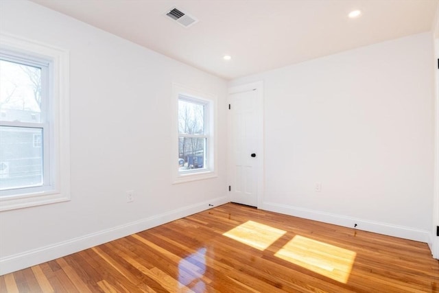 spare room with light wood-type flooring, visible vents, baseboards, and recessed lighting