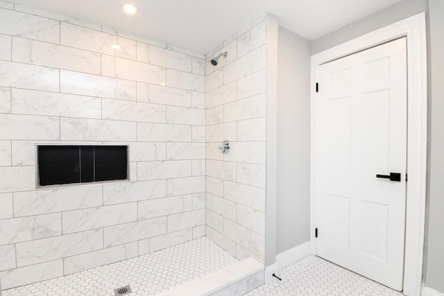 bathroom with a stall shower, tile patterned flooring, and baseboards