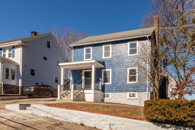 view of front of property featuring a porch and a chimney