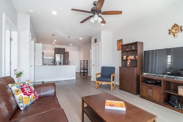 living room featuring ceiling fan and light wood-type flooring