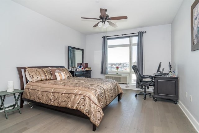 bedroom with wood-type flooring, an AC wall unit, and ceiling fan