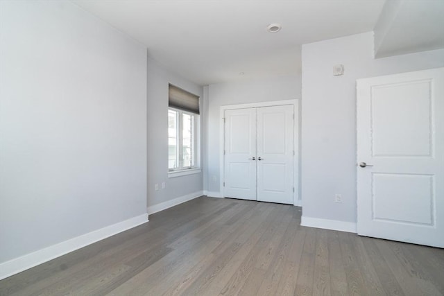 unfurnished bedroom with hardwood / wood-style flooring and a closet