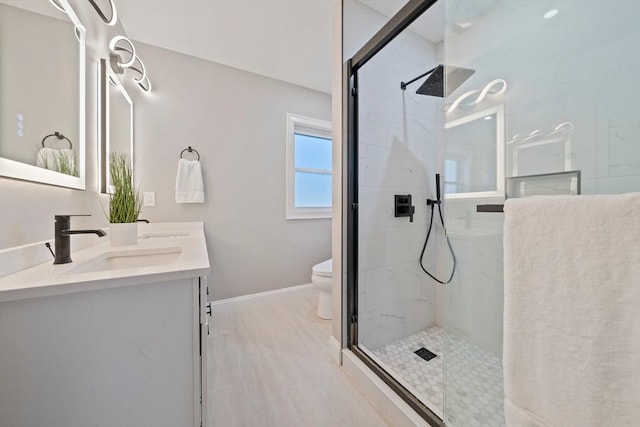 full bath with a shower with shower door, a sink, toilet, and double vanity