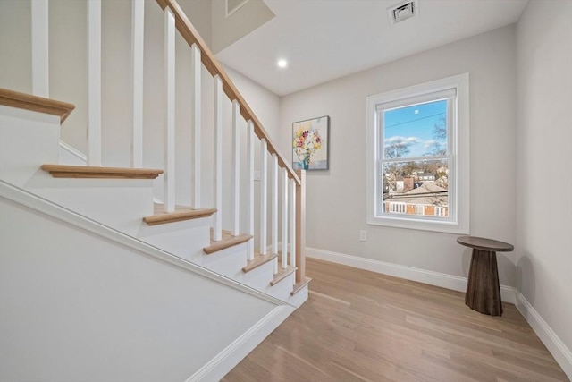 stairway with recessed lighting, visible vents, baseboards, and wood finished floors