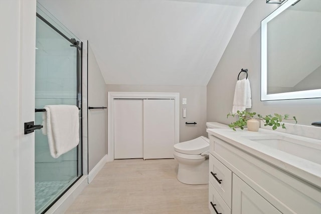 bathroom featuring lofted ceiling, a stall shower, toilet, and vanity