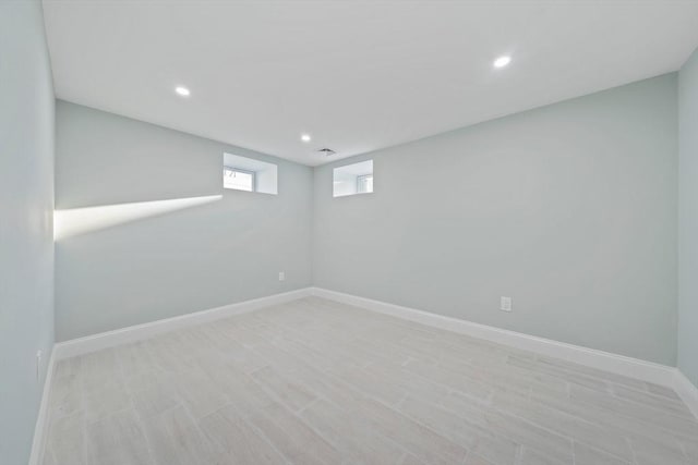 basement with light wood-type flooring, recessed lighting, visible vents, and baseboards