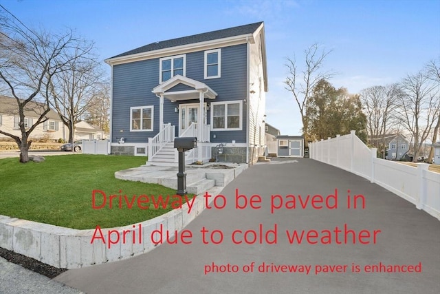 view of front of home featuring fence and a front lawn