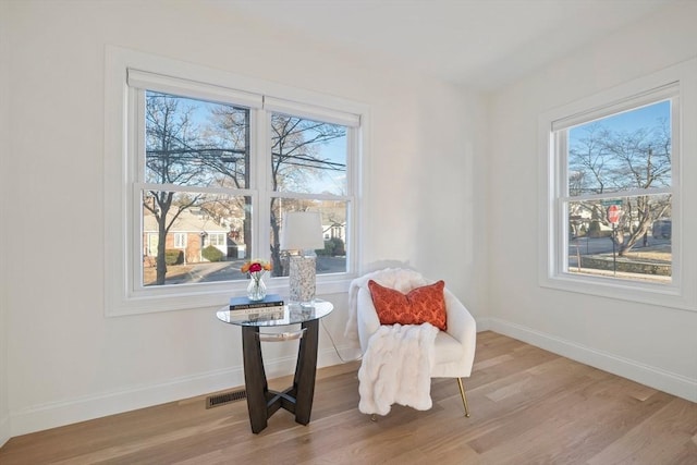 sitting room featuring visible vents, baseboards, and wood finished floors