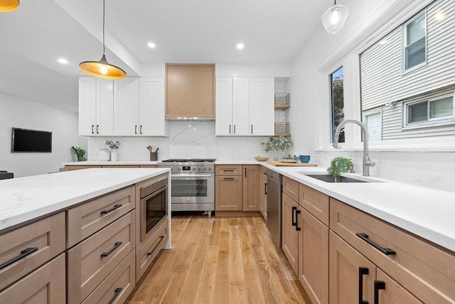 16 Edgar Ave, Somerville, MA 02145 - kitchen featuring appliances with stainless steel finishes, a sink, wall chimney range hood, tasteful backsplash, and light wood finished floors