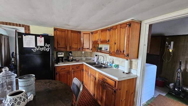 kitchen with sink, black refrigerator, and decorative backsplash