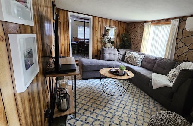 living room with wooden walls and a healthy amount of sunlight