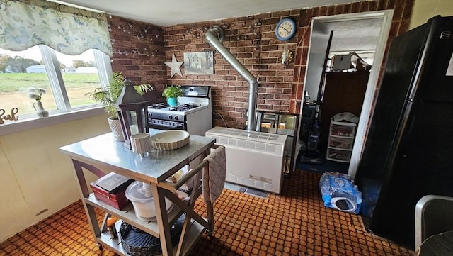 dining space with heating unit, brick wall, and a wood stove