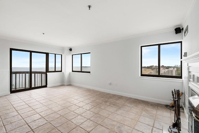 empty room with ornamental molding, baseboards, and fire sprinkler in ceiling