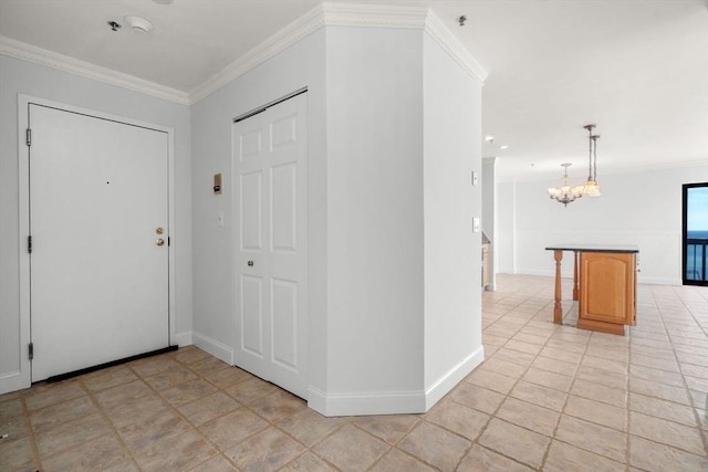 entrance foyer featuring a chandelier, crown molding, and baseboards