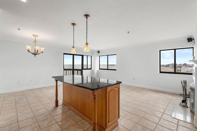 kitchen featuring plenty of natural light, ornamental molding, a chandelier, a breakfast bar, and dark countertops