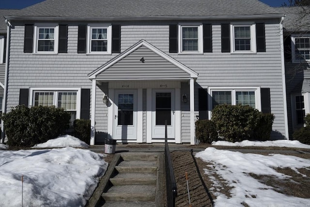 colonial home featuring a shingled roof