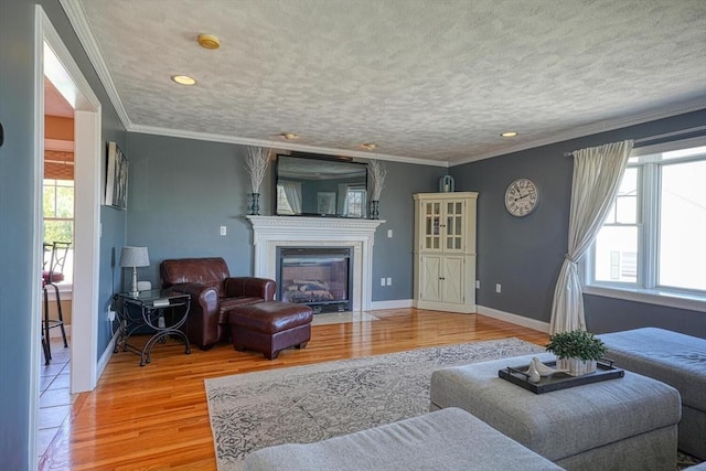 living area featuring a fireplace with flush hearth, recessed lighting, baseboards, and light wood finished floors