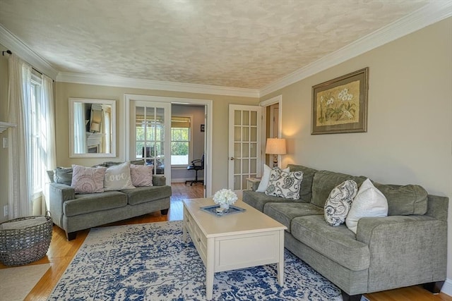 living room with light wood-style floors, ornamental molding, and a textured ceiling