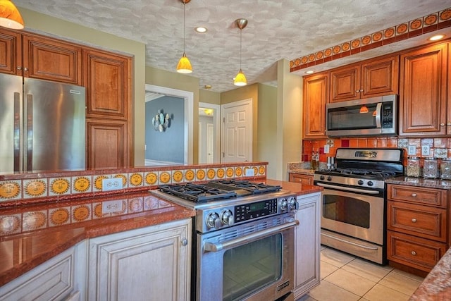 kitchen featuring stainless steel appliances, a textured ceiling, hanging light fixtures, and decorative backsplash