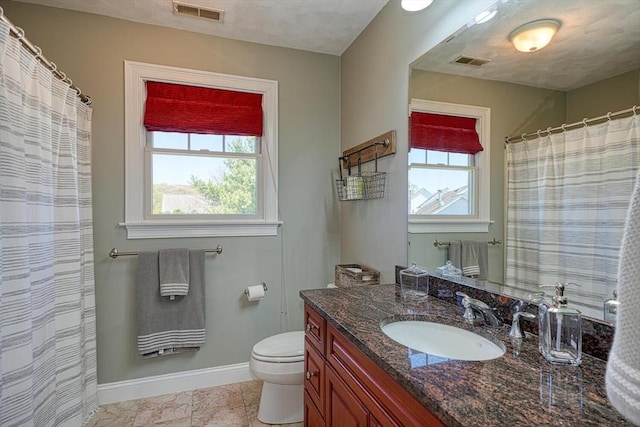 bathroom with baseboards, vanity, toilet, and visible vents