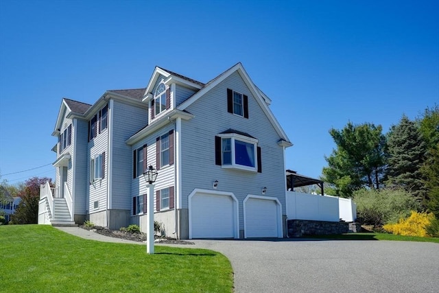 view of front of home with an attached garage, driveway, and a front yard