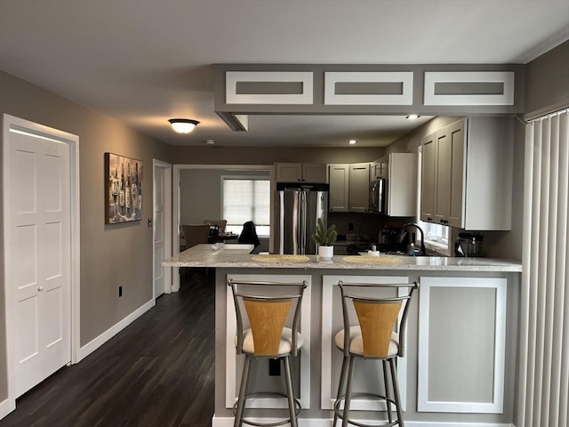 445 Cambridge St, Worcester, MA 01610 - kitchen featuring stainless steel appliances, gray cabinetry, a peninsula, baseboards, and dark wood-style flooring