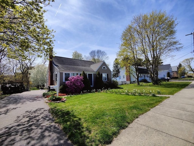 view of front of property featuring driveway and a front lawn