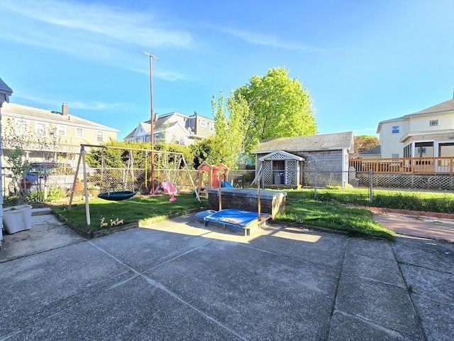 exterior space with an outbuilding, a playground, fence, and a storage shed