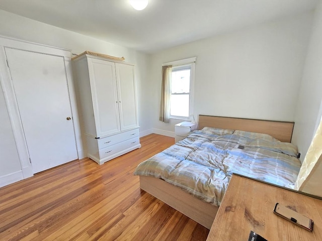 bedroom featuring baseboards and light wood-style flooring