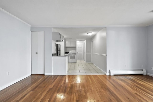 kitchen featuring a baseboard heating unit, light wood-style floors, freestanding refrigerator, white range with electric cooktop, and dark countertops