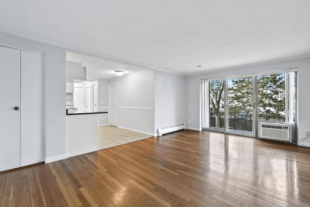 unfurnished living room with baseboards, baseboard heating, crown molding, light wood-type flooring, and a wall mounted AC