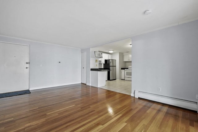 unfurnished living room featuring light wood-style floors and baseboard heating