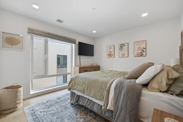 bedroom with light wood-type flooring and multiple windows