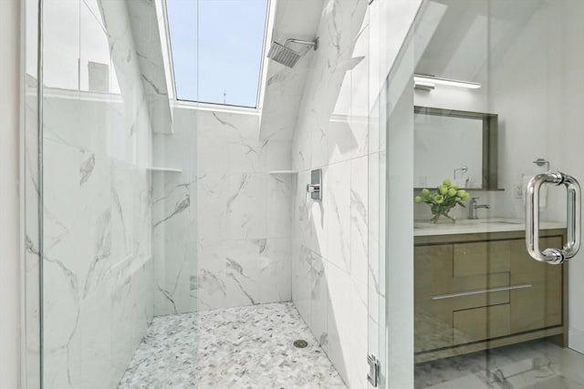 full bath featuring a marble finish shower and vanity