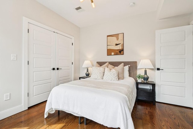 bedroom featuring wood finished floors, a closet, and baseboards