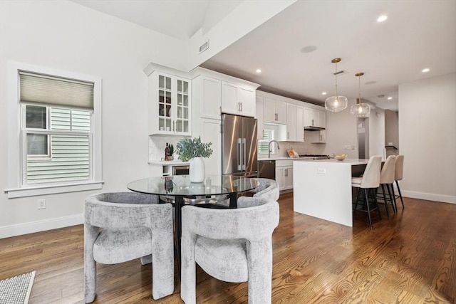 dining area featuring baseboards, wood finished floors, and recessed lighting