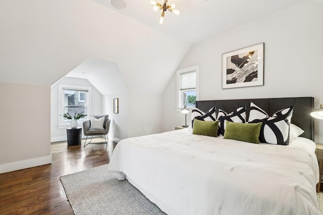 bedroom featuring wood finished floors, lofted ceiling, and baseboards