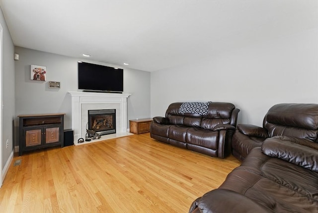 living area with recessed lighting, wood finished floors, and a fireplace