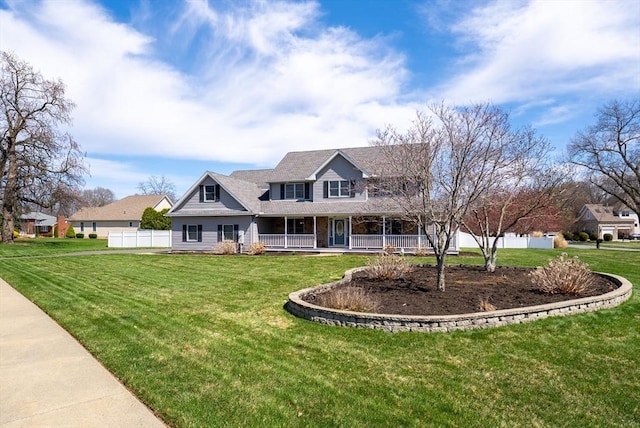 view of front of home featuring fence, covered porch, and a front yard