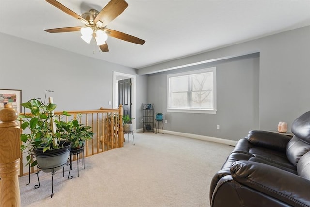 carpeted living room featuring a ceiling fan and baseboards