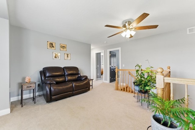 living area with carpet, visible vents, baseboards, and ceiling fan