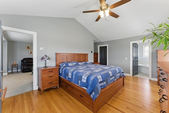 bedroom with lofted ceiling, a ceiling fan, ensuite bathroom, and light wood-type flooring