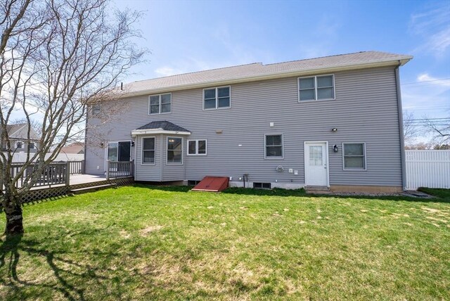 back of property with a lawn and a deck