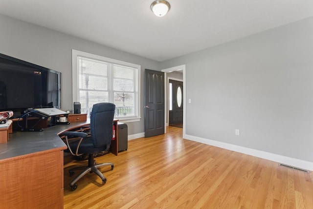 home office with light wood-style floors, visible vents, and baseboards
