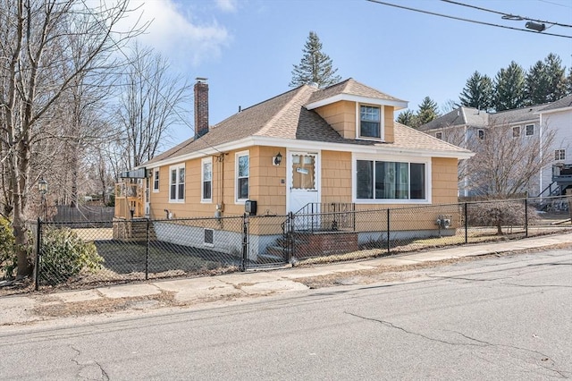 view of front of house featuring a shingled roof, a fenced front yard, and a chimney