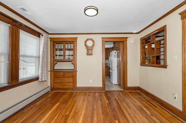 empty room with visible vents, ornamental molding, a baseboard heating unit, wood-type flooring, and baseboards