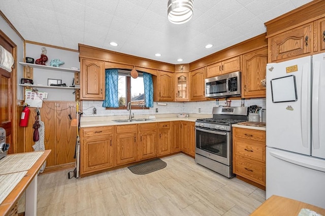 kitchen with a sink, light countertops, brown cabinets, stainless steel appliances, and open shelves