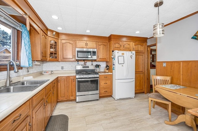 kitchen with glass insert cabinets, light countertops, appliances with stainless steel finishes, brown cabinetry, and a sink